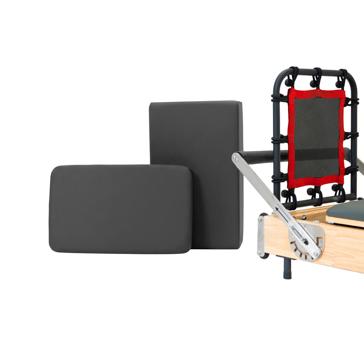 Two rectangular black foam cushions with a smooth texture, positioned next to a reformer machine featuring a wooden frame and red accents