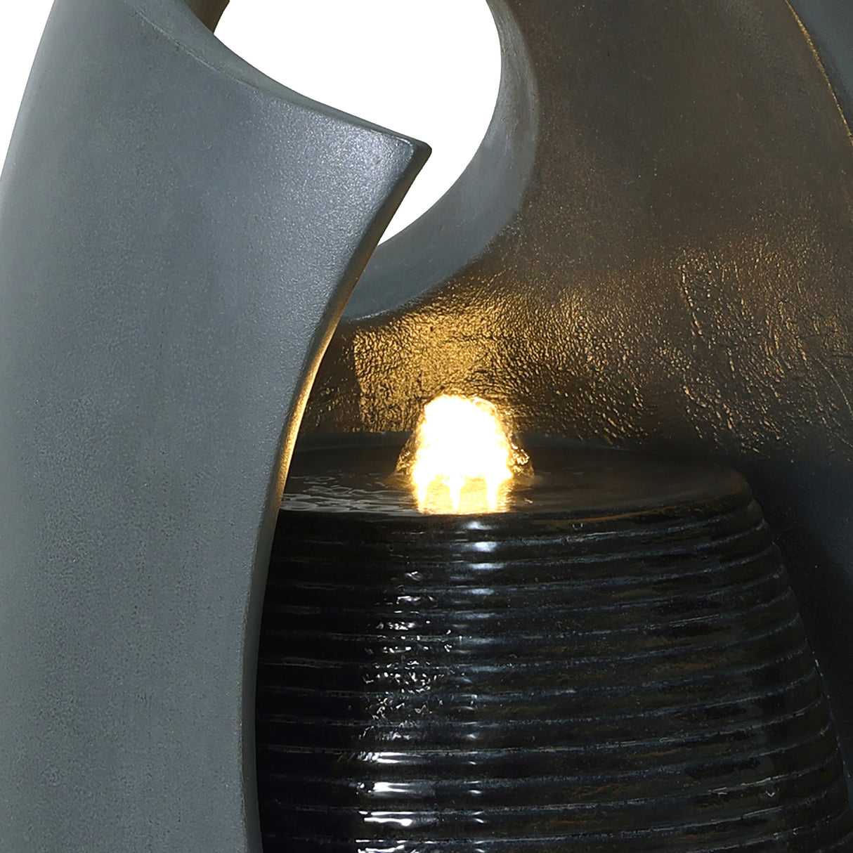 Sleek gray electric water feature with cascading falls, illuminated by a warm glow, highlighting textured surfaces and modern design