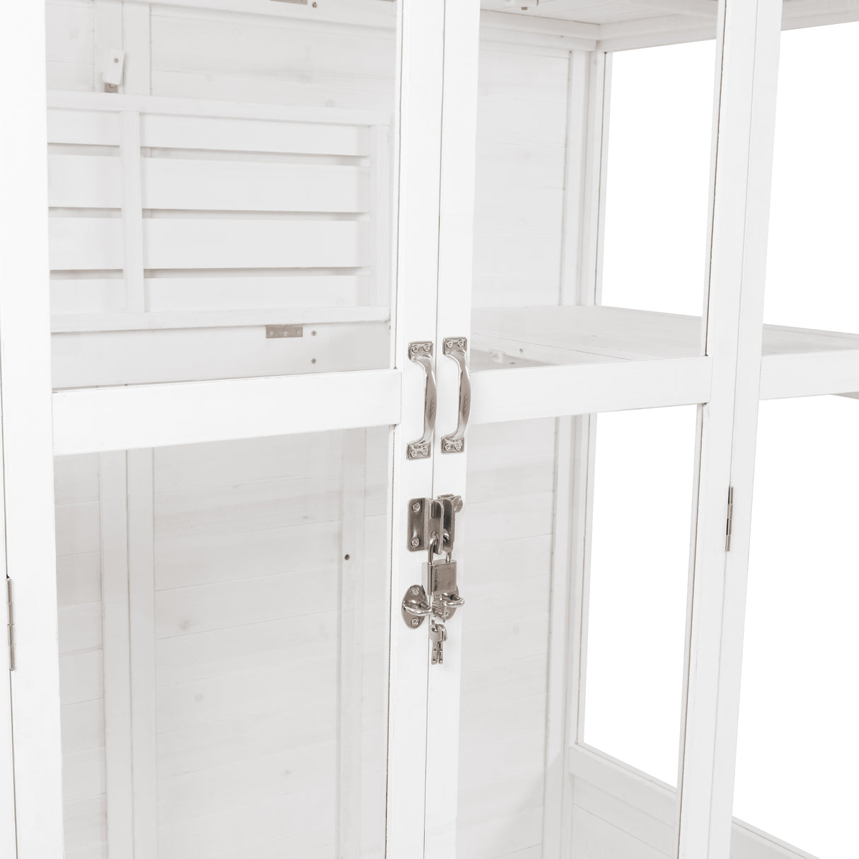 Elegant Victorian greenhouse in white wood, featuring glass panels, sleek metal handles, and a secure lock for plant protection