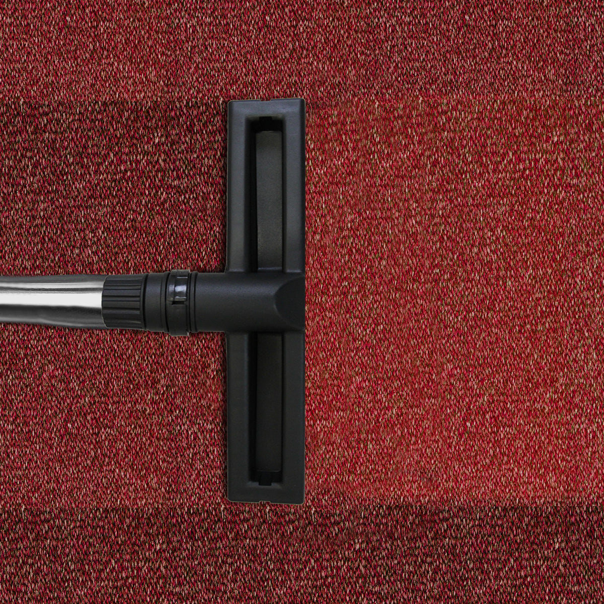 Black nozzle of a 90L Maxblast industrial vacuum on textured red carpet, showcasing its wet and dry cleaning capabilities