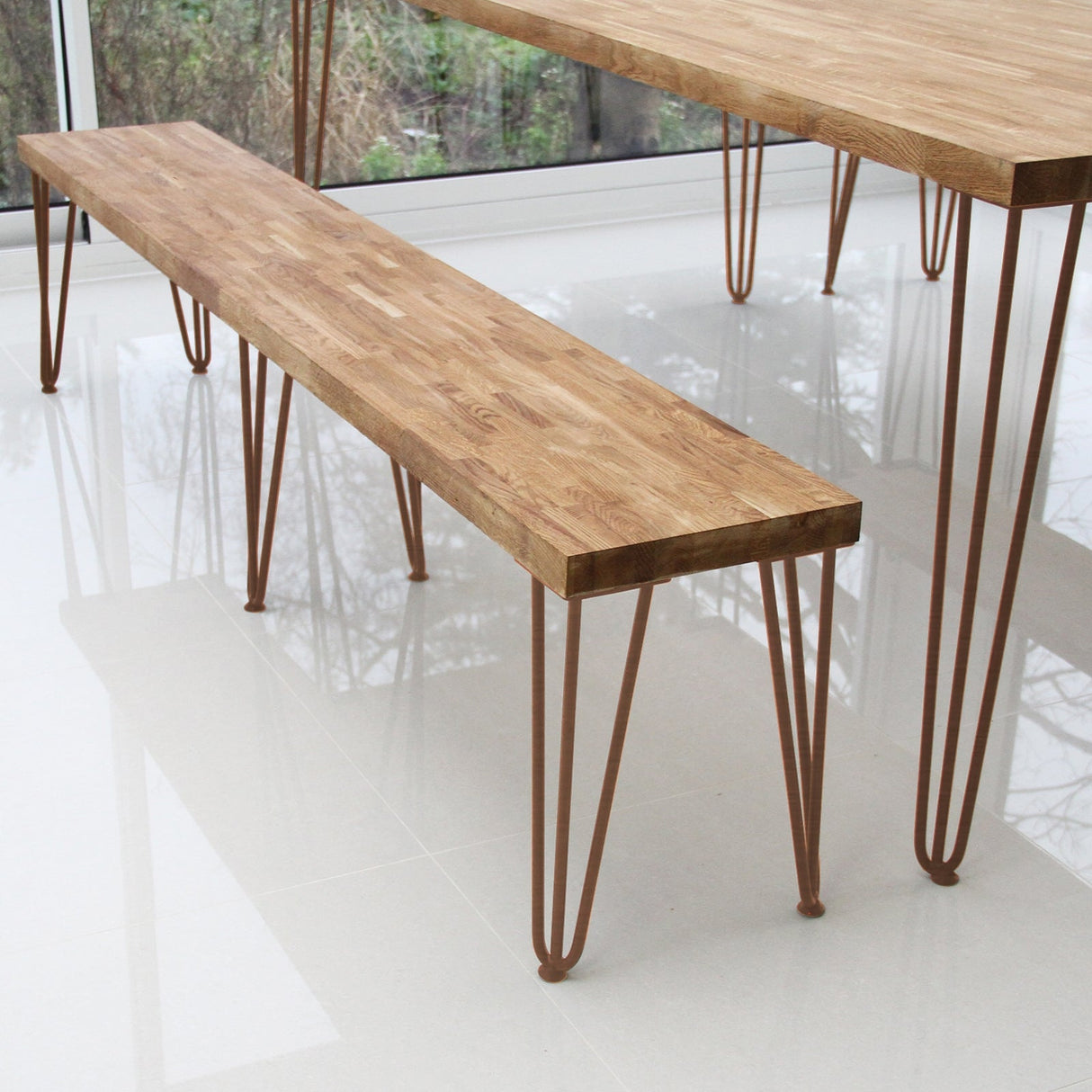 Antique copper hairpin legs with a sleek, minimalist design supporting a wooden bench, showcasing a warm, natural wood grain texture