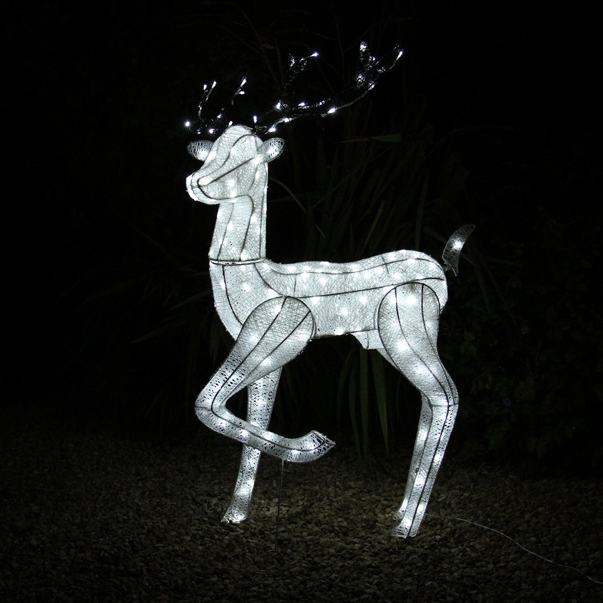 Large light-up stag reindeer with a sleek white frame, illuminated by bright LED lights, standing gracefully against a dark background