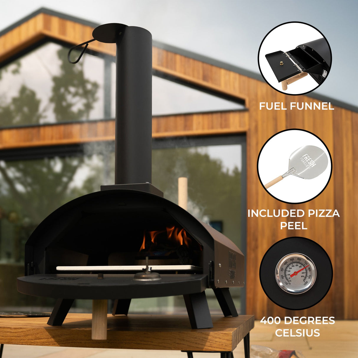 Classic outdoor pizza oven with a sleek black finish, chimney, wooden peel, and a temperature gauge, set against a modern backdrop