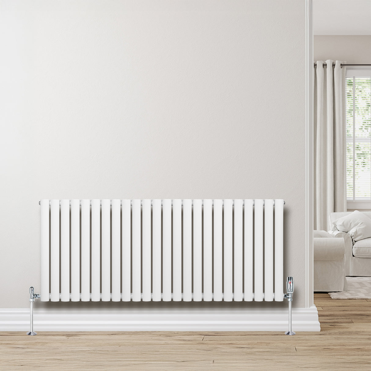 Sleek white oval single column radiator with vertical slats, mounted on a light wooden floor against a neutral wall, enhancing modern decor