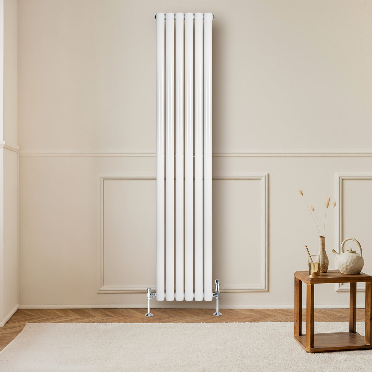 Sleek white oval single column radiator with five vertical panels, mounted on a light-colored wall, beside a wooden table
