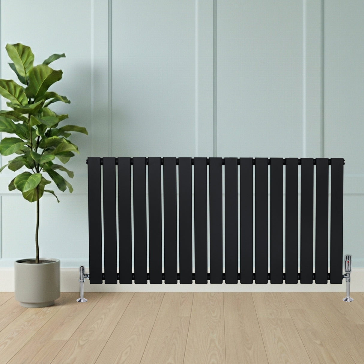 Sleek black flat single column radiator with polished valves, positioned beside a potted plant on a light wooden floor
