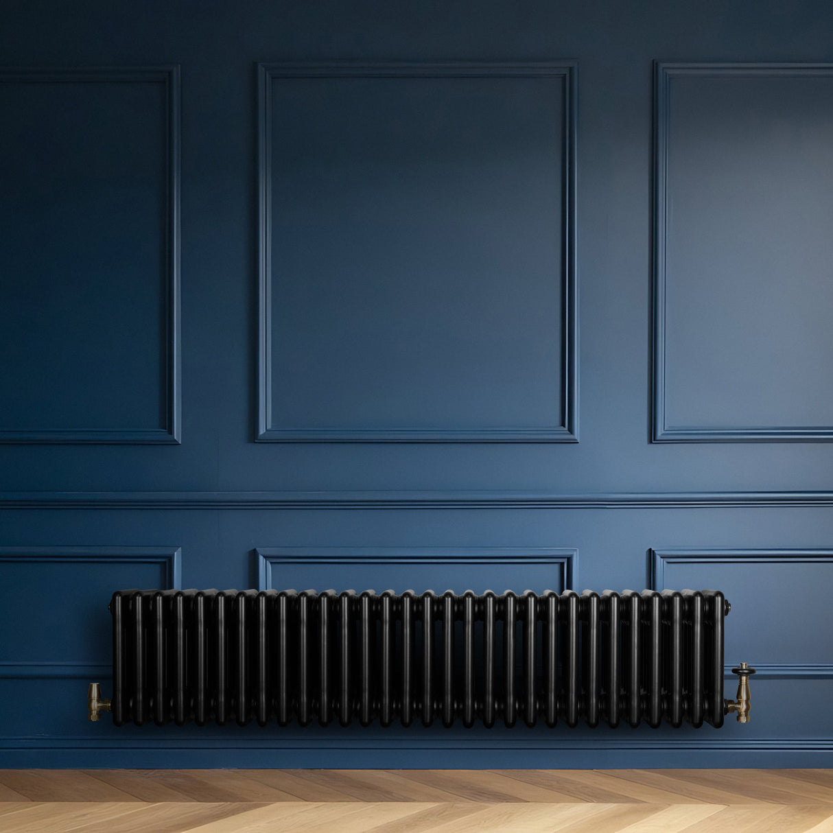 Traditional black 4 column radiator with brass valves, mounted against a deep blue wall, showcasing a sleek, modern design