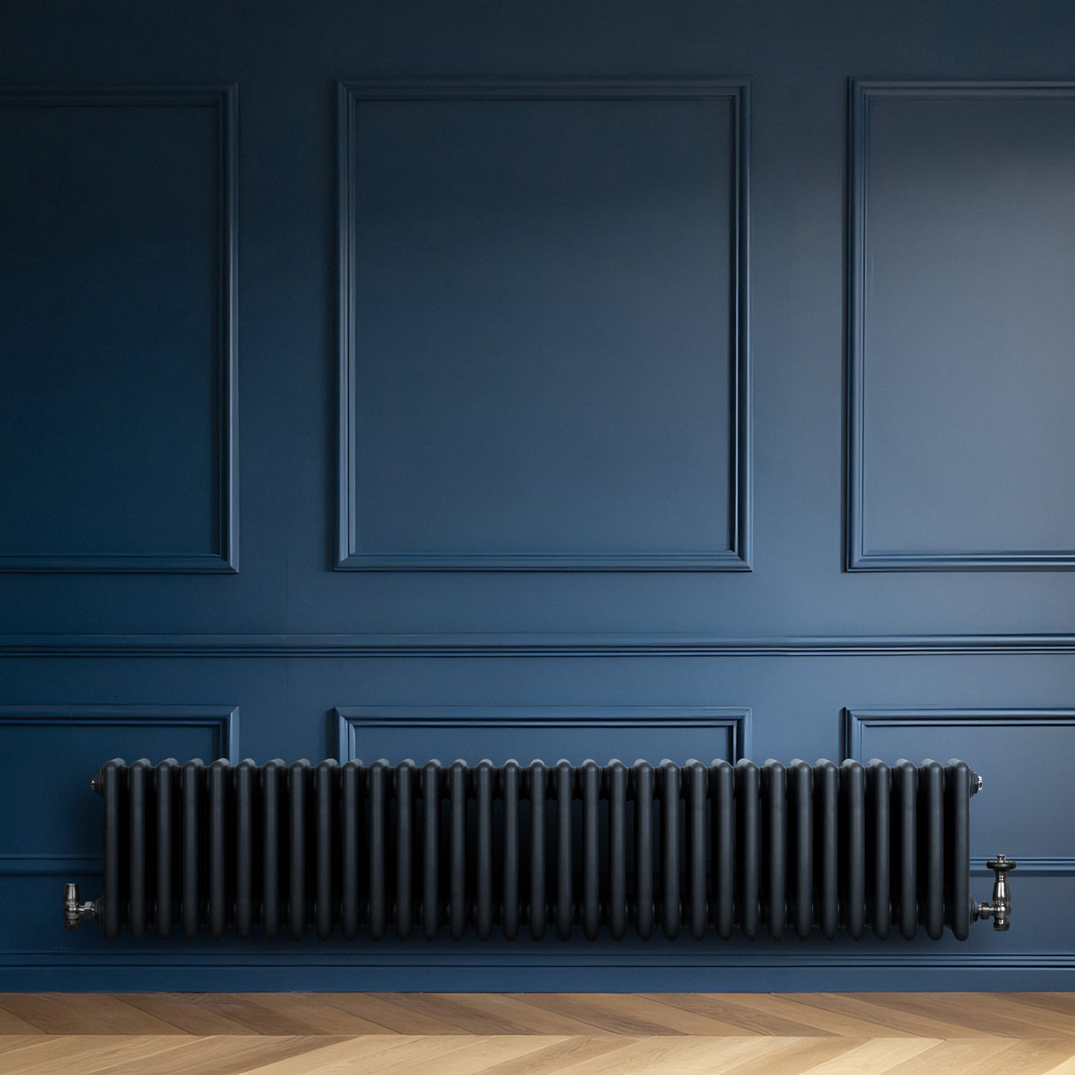 Traditional anthracite grey 4 column radiator with sleek, rounded edges, mounted against a deep blue wall, enhancing modern decor