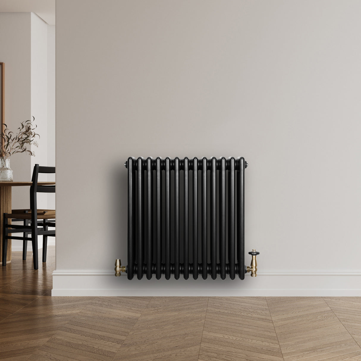 Traditional black 4 column radiator with brass valves, featuring a sleek, smooth finish and modern design, mounted on a wall