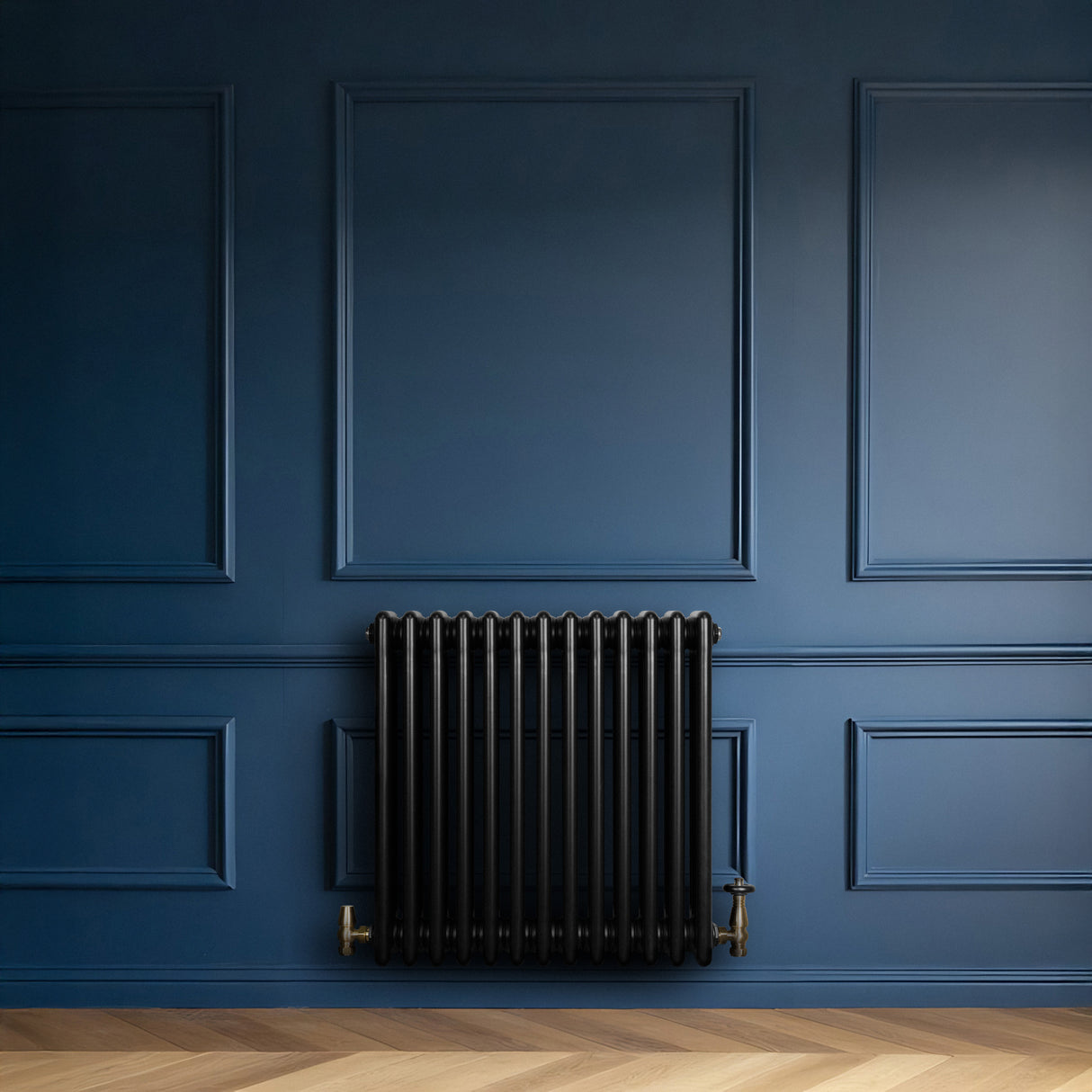 Traditional black 4 column radiator with brass valves against a deep blue wall, featuring a sleek, modern design and textured finish