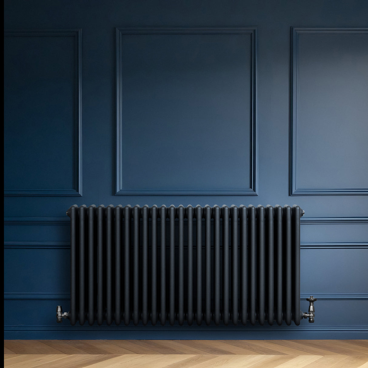 Traditional anthracite grey 4 column radiator with smooth, rounded edges, mounted on a deep blue wall, enhancing modern decor