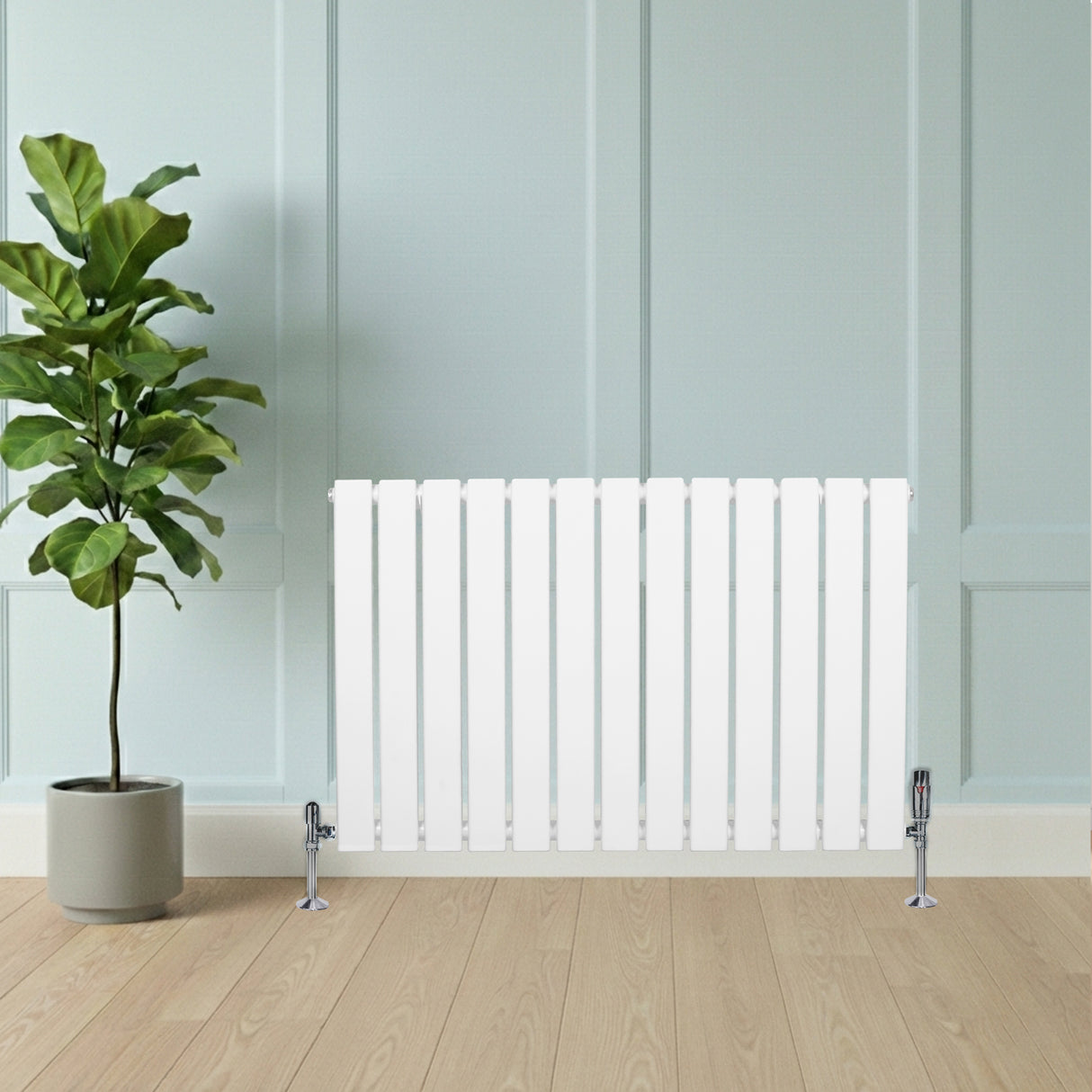 Sleek white flat single column radiator with vertical slats, positioned beside a potted plant against a light blue wall