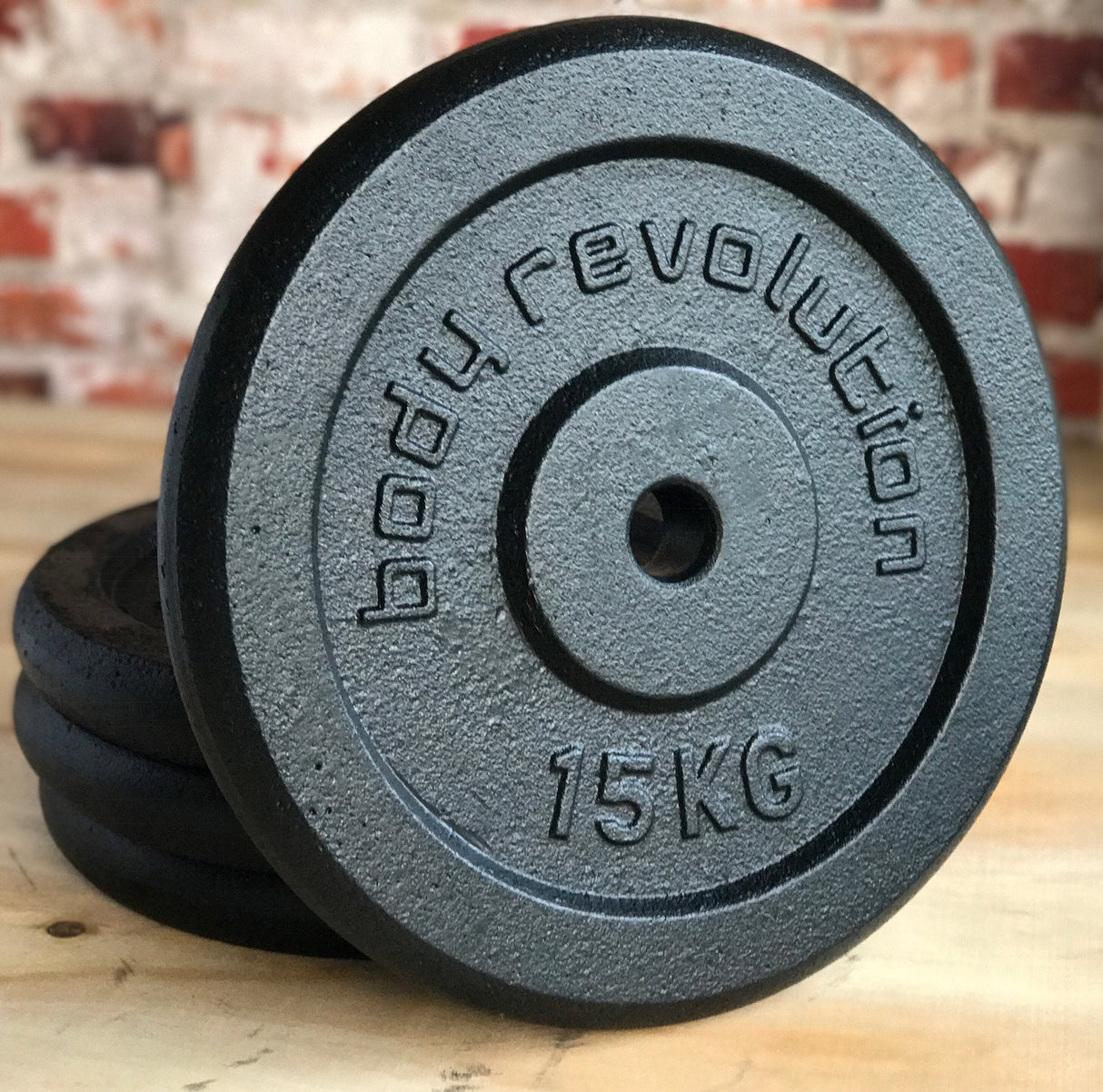 Heavy-duty cast iron weight plates in black, featuring raised lettering and a smooth texture, each marked with 15KG for easy identification