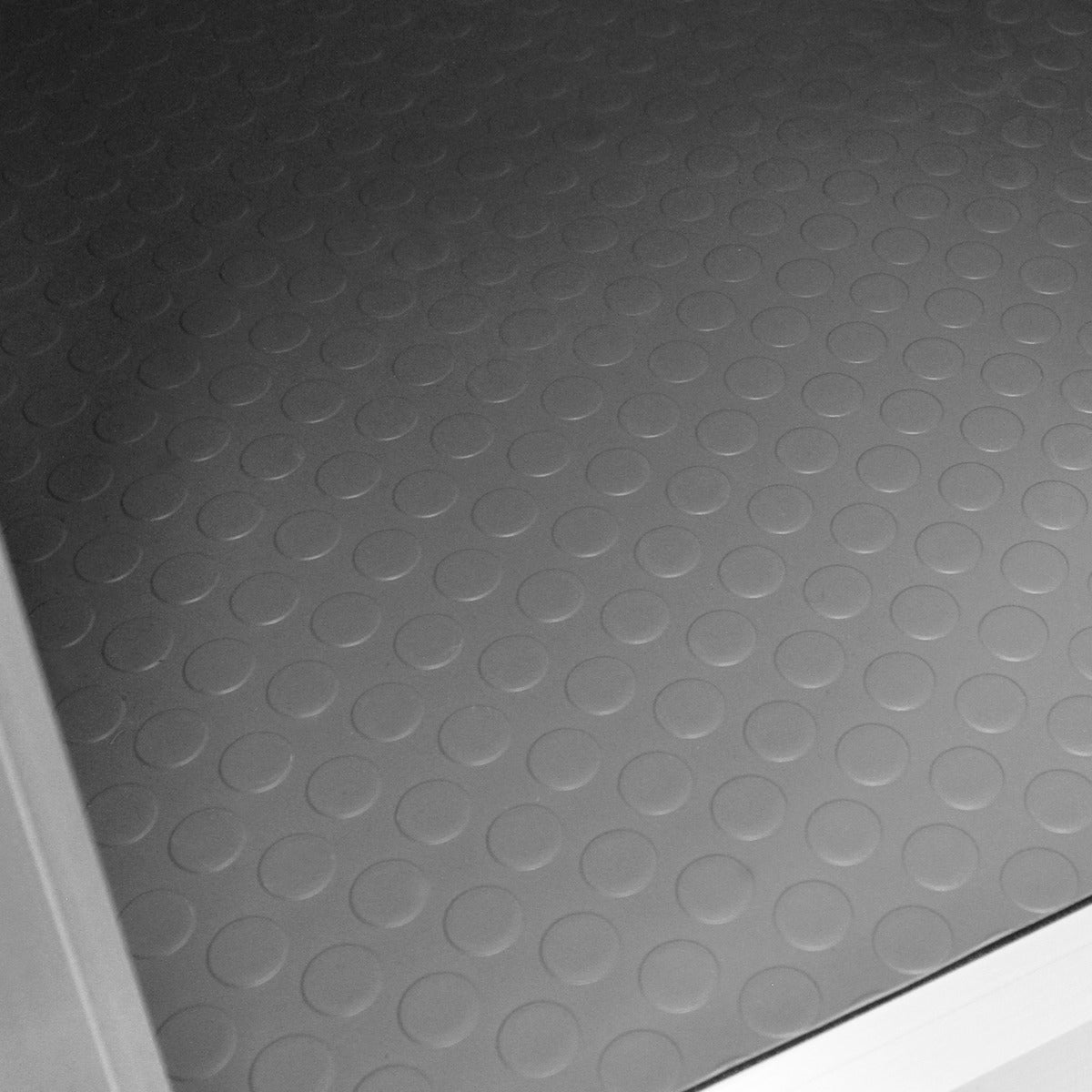 Textured gray rubber flooring with circular patterns, providing a non-slip surface for a car dog pet crate with large double doors