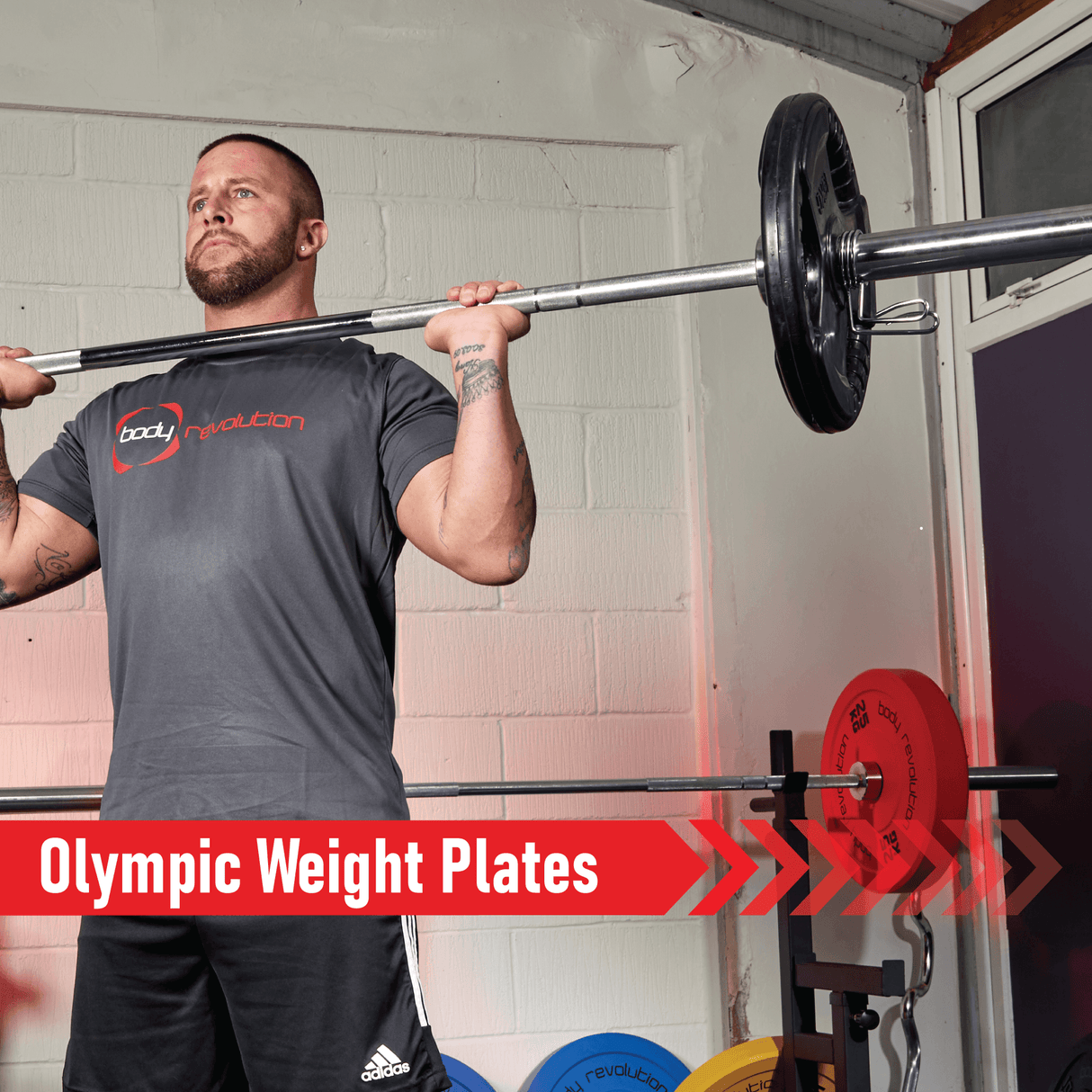 Black Olympic tri-grip rubber weight plates stacked on a barbell, showcasing durability and grip for effective weightlifting workouts