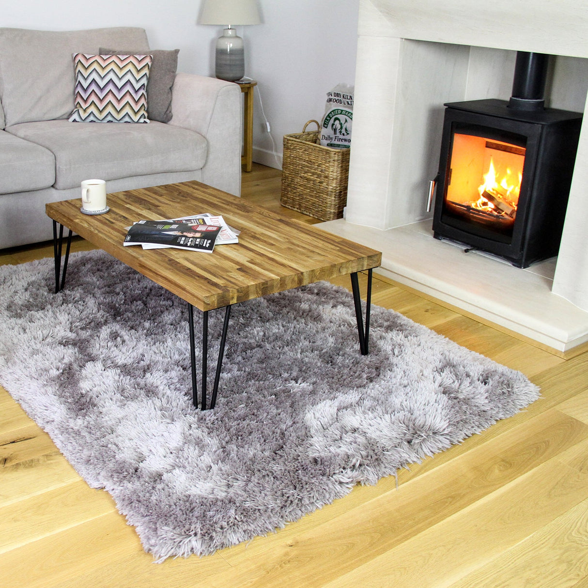 Stylish coffee table with raw steel hairpin legs, a rustic wooden top, and a cozy living room setting featuring a warm fireplace
