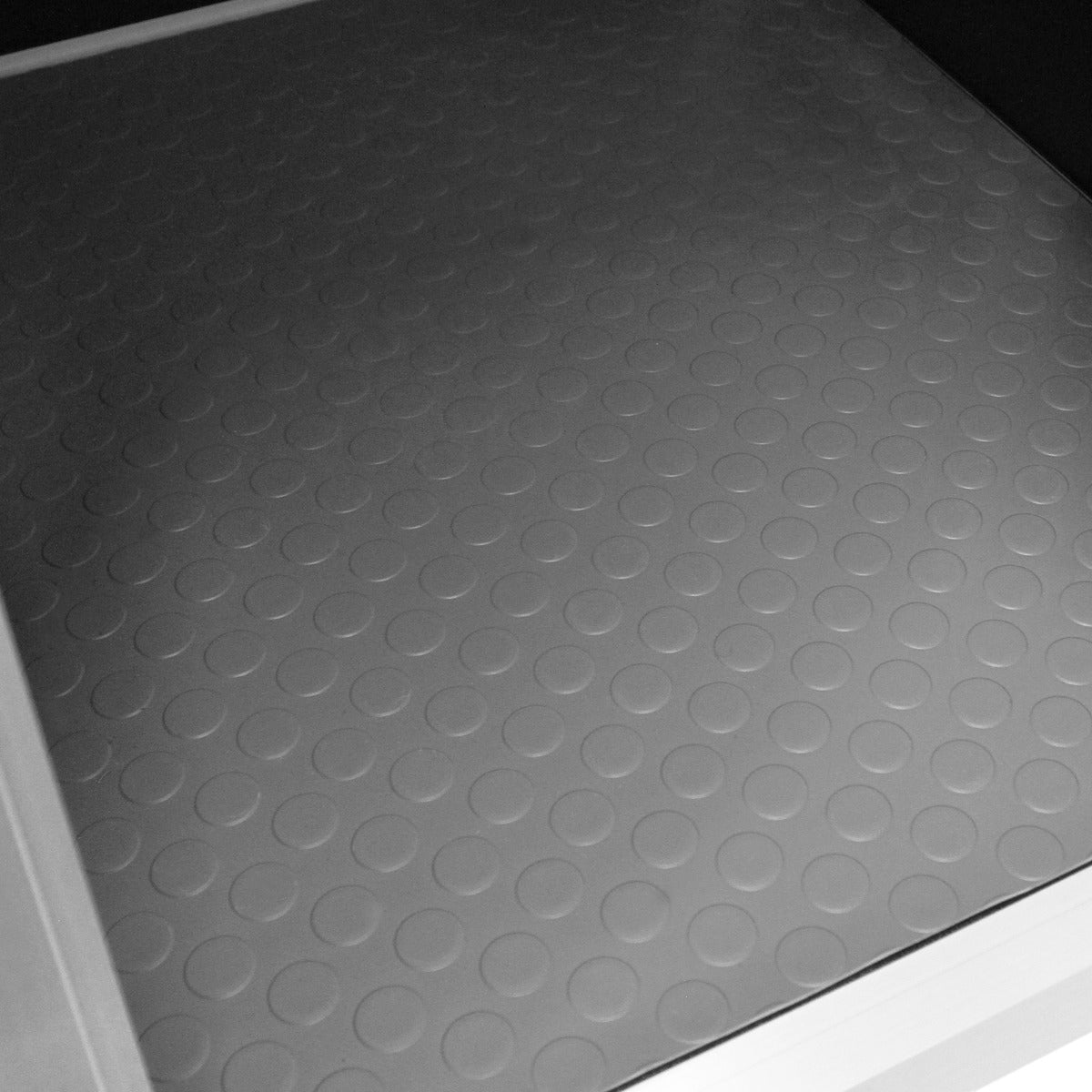 Textured gray rubber mat with circular patterns inside a small dog crate, designed for comfort and easy cleaning