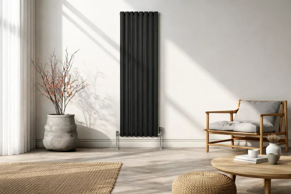 Sleek black column radiator stands against a light wall in a modern living room with natural light, a cozy chair, and decorative plant