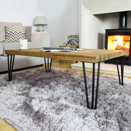 Stylish wooden coffee table with hairpin legs, set on a plush gray rug, near a cozy fireplace, enhancing modern decor