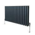 Anthracite grey oval column radiator with vertical fins and polished valves, standing on sleek chrome feet, ideal for modern interiors