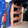 Wooden shelving unit with three open shelves, mounted inside a blue Citroën Berlingo II van, showcasing tools and storage items