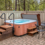 Brown 2.1m hot tub spa cover with a sleek design, surrounded by wooden steps and a stone patio, nestled in a forested area