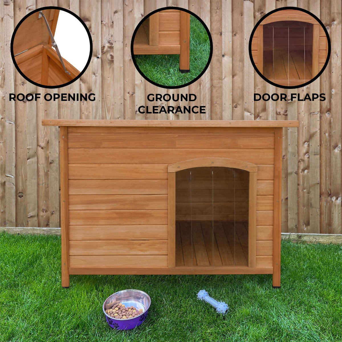 Large wooden dog kennel with a slanted roof, ground clearance, and door flaps, set on green grass against a wooden fence
