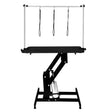Hydraulic grooming table with a sleek black top, sturdy black frame, and adjustable height, featuring three grooming loops for secure pet handling