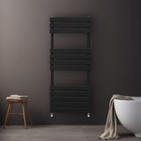 Sleek black flat panel towel radiator mounted on a dark wall, featuring horizontal slats and a modern design, ideal for bathrooms
