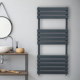 Sleek anthracite grey flat panel towel radiator with horizontal slats, mounted on a light wall in a modern bathroom setting