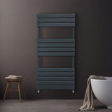 Sleek anthracite grey flat panel towel radiator mounted on a dark wall, featuring horizontal slats and a modern design, with a soft towel draped nearby