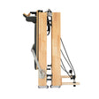 Sleek oak Pilates reformer machine in a compact, upright position showcasing its smooth wood finish and adjustable resistance cables