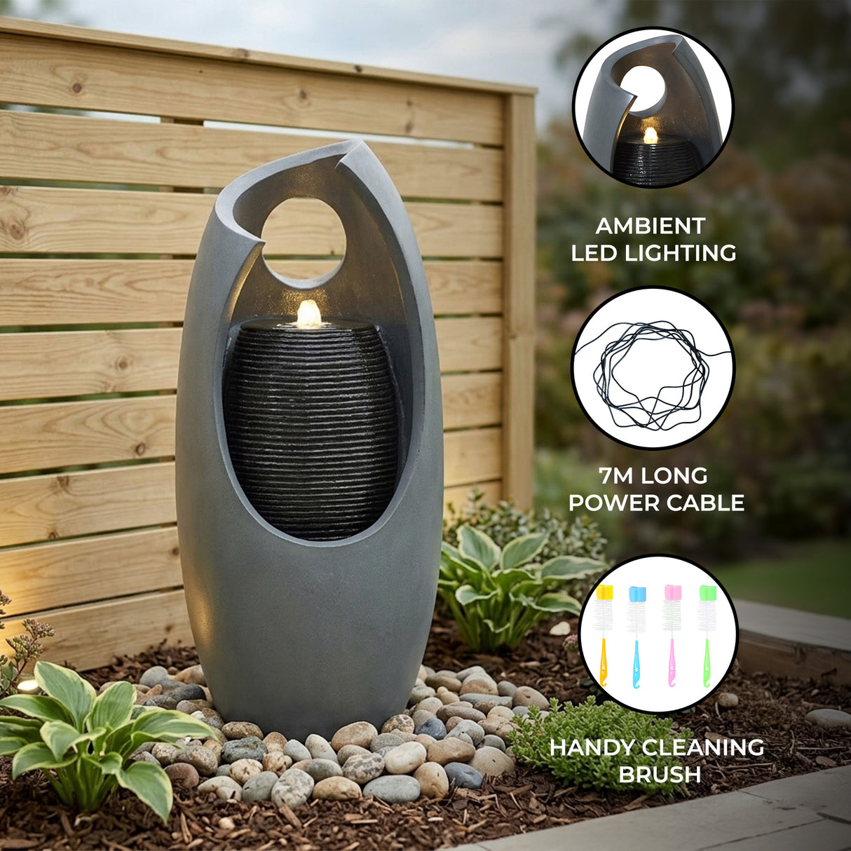 Sleek gray electric water feature with ambient LED lighting, cascading water, and a modern design, surrounded by decorative stones and plants