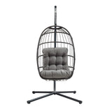Black rattan hanging egg chair with a plush gray cushion, featuring a sturdy metal stand and a modern, stylish design