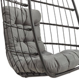 Black rattan hanging egg chair featuring a plush gray cushion, showcasing a modern design with a sleek, woven texture and curved shape