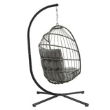 Grey rattan hanging egg chair with plush cushions, suspended from a sleek black metal stand, perfect for indoor or outdoor relaxation