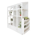 Victorian-style white greenhouse with glass panels, showcasing potted plants and a wooden shelf for gardening supplies