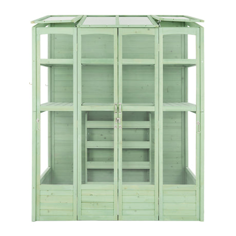 Victorian-style greenhouse in a soft green hue, featuring wooden panels, glass roof, and multiple shelves for plants and gardening tools