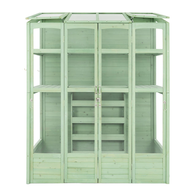 Victorian-style greenhouse in a soft green hue, featuring wooden panels, glass roof, and multiple shelves for plants and gardening tools