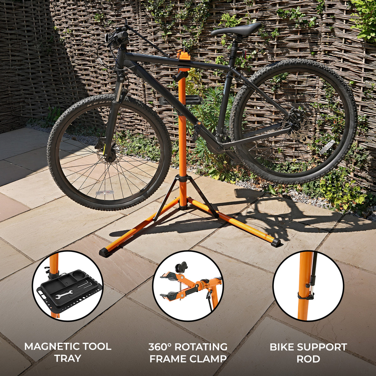 Sturdy bike mechanic repair stand with a black mountain bike, featuring an orange frame, magnetic tool tray, and 360° rotating clamp