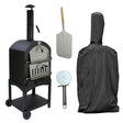Black KuKoo outdoor pizza oven with stainless steel accents, pizza peel, cutter, and protective cover, ideal for backyard cooking