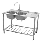 Stainless steel commercial catering sink with double bowls, right-hand drainer, and adjustable faucet on a sturdy frame