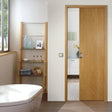Natural wood single pocket door kit in a modern bathroom setting, featuring sleek lines and a minimalist design with a light oak finish