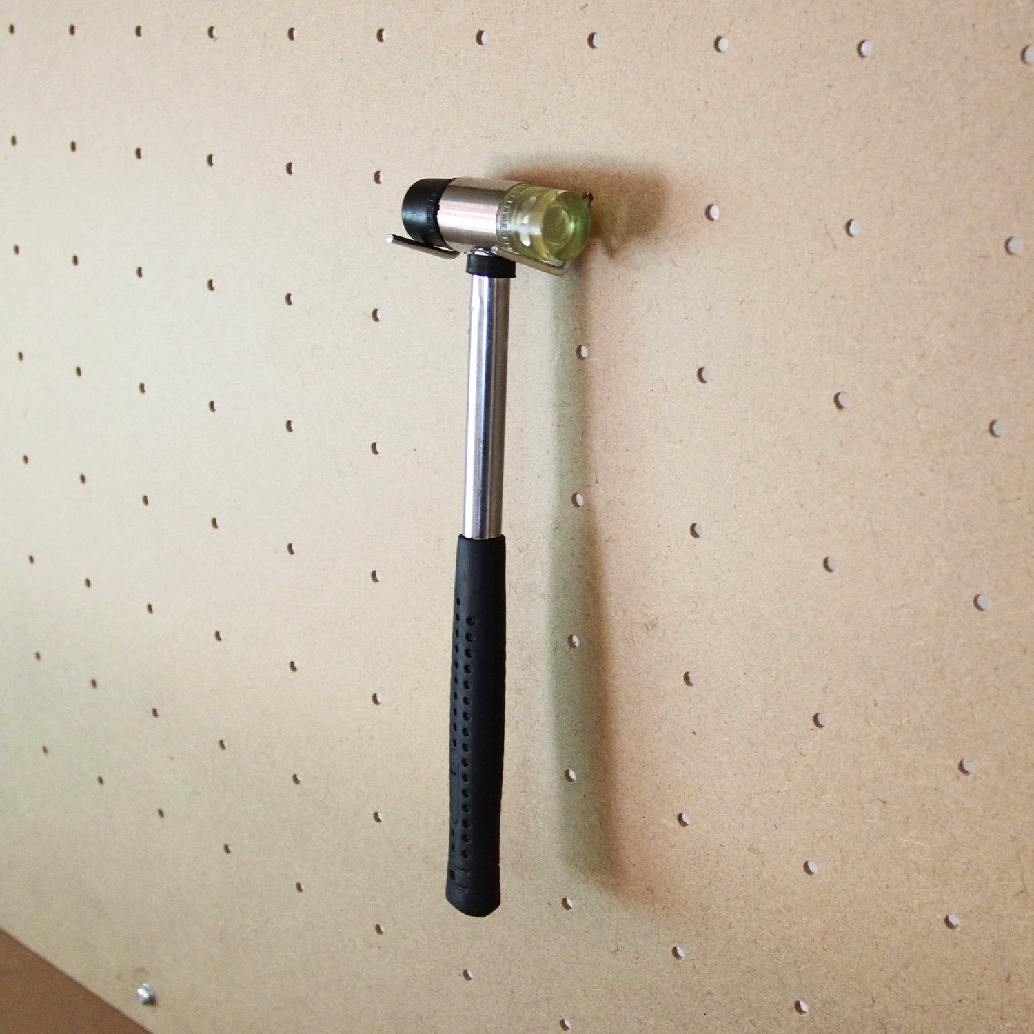 Red workbench featuring a pegboard and drawer, with a silver hammer hanging on the pegboard, showcasing a sturdy design and practical storage