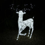 Glowing white reindeer with antlers, adorned with bright lights, standing on a gravel surface, perfect for festive outdoor decor