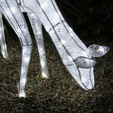 Glowing white reindeer stag with intricate lace-like texture, standing on pebbled ground, perfect for festive outdoor decor