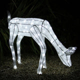 Glowing white reindeer silhouette with intricate cutouts, standing gracefully among pebbles, perfect for festive outdoor decor