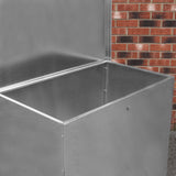 Galvanised feed store with a single compartment, featuring a shiny metal finish and a spacious, open interior against a brick background