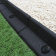Flexible black lawn edging, 1.2m long, featuring a textured surface, neatly separating gravel and lush green grass