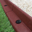Flexible terracotta lawn edging, 1.2m long, with a textured surface, curved shape, and black connectors, alongside gravel and grass